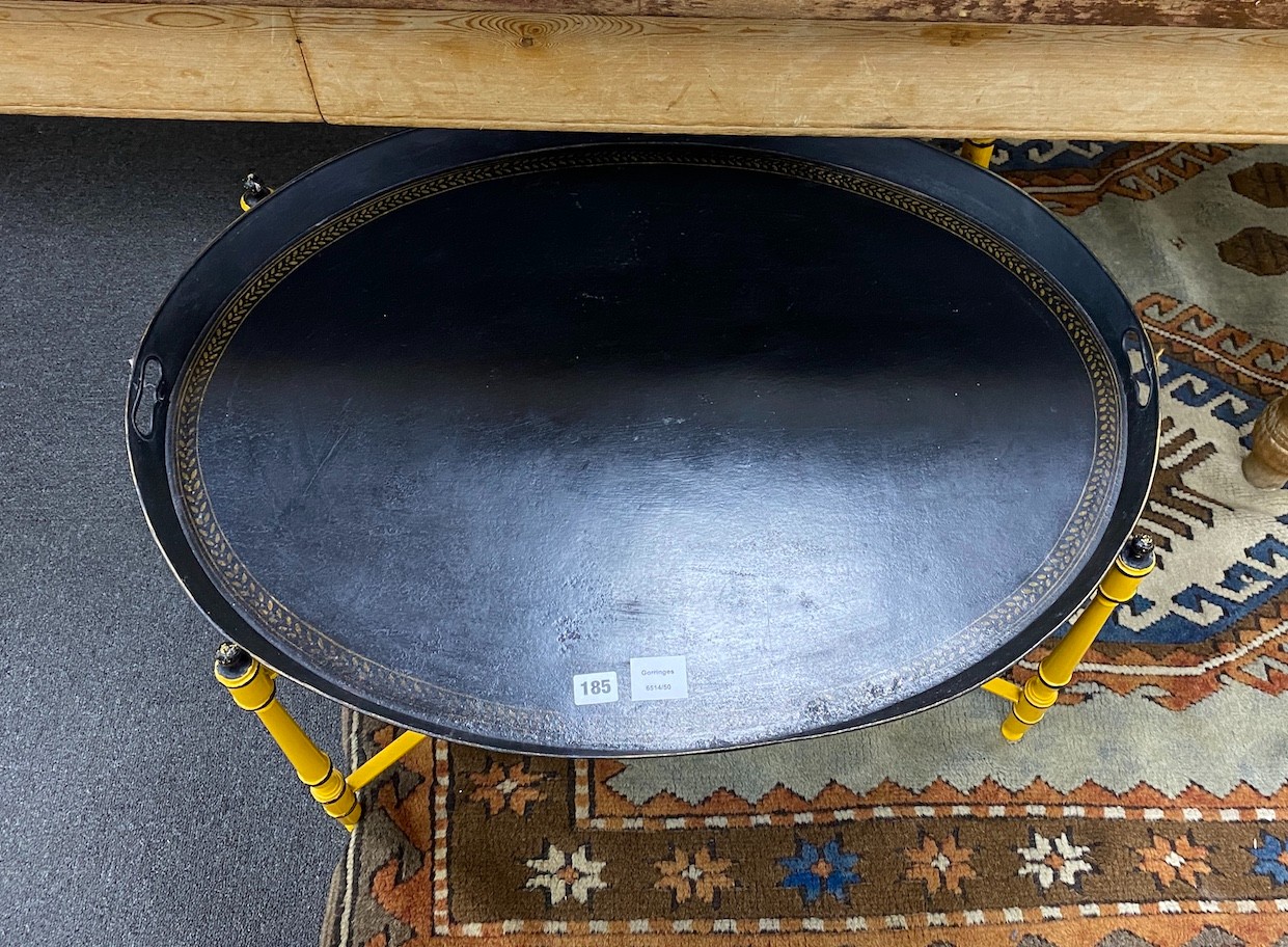 An oval Regency style black japanned tin tray on folding stand, tray width 80cm, depth 61cm, height 45cm
